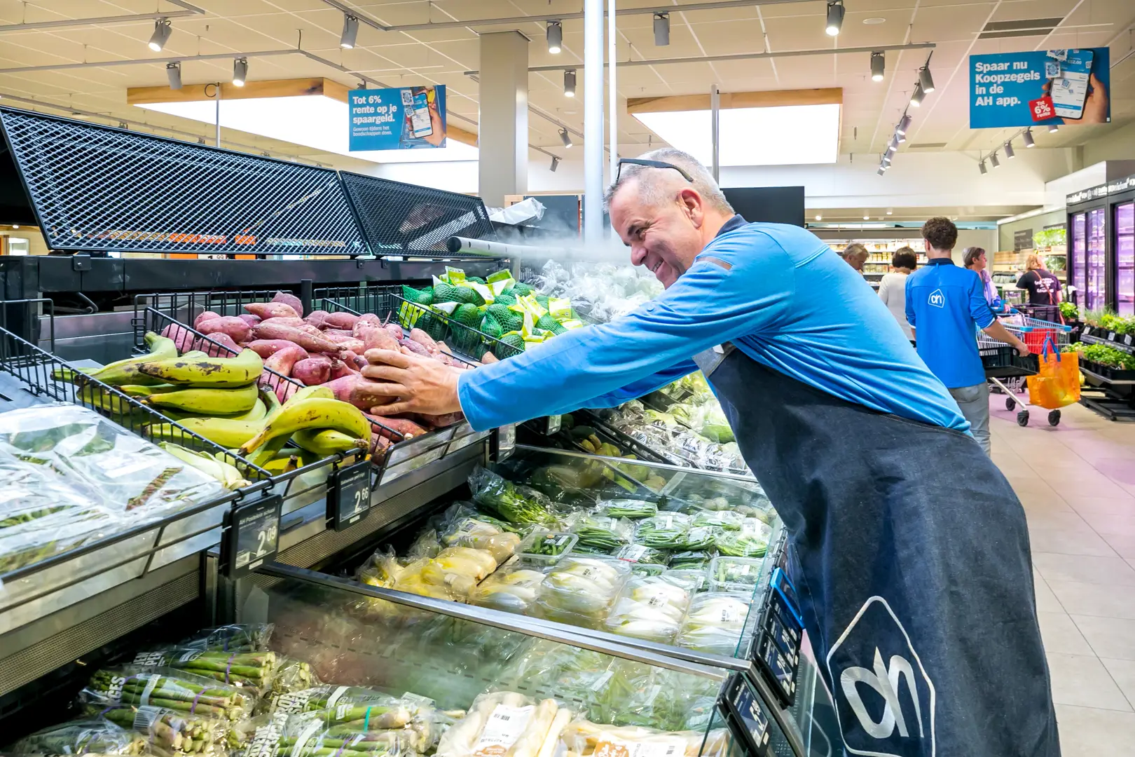 employee arranging vegetables in an Albert Heijn store